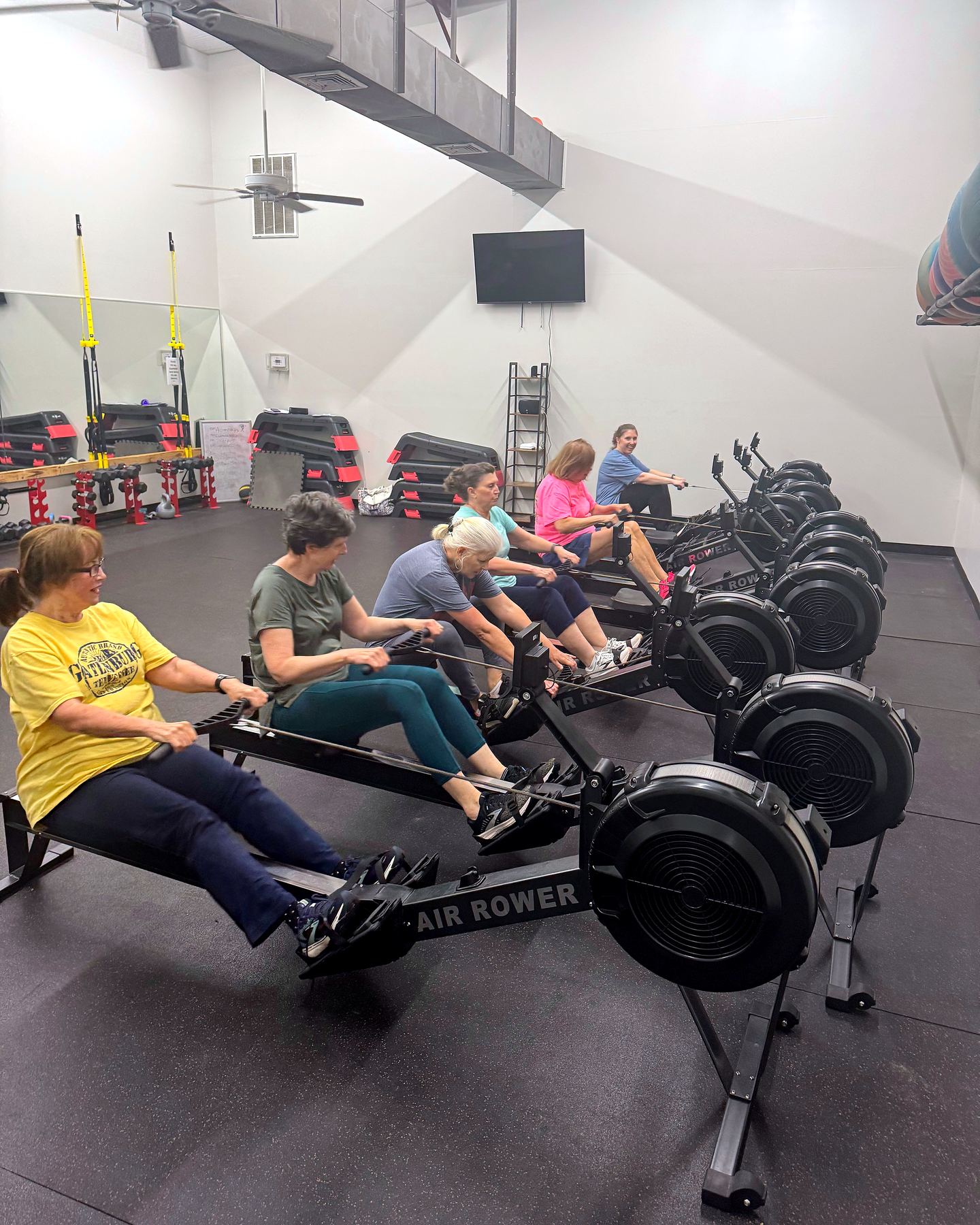 Members working out on air rowers during the senior aerobics class